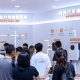 Crowd at a tech exhibition booth showcasing Hybrid AC-DC and Off-Grid Home ESS systems with large bilingual signage.